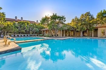 A large swimming pool with a sunny sky in the background.